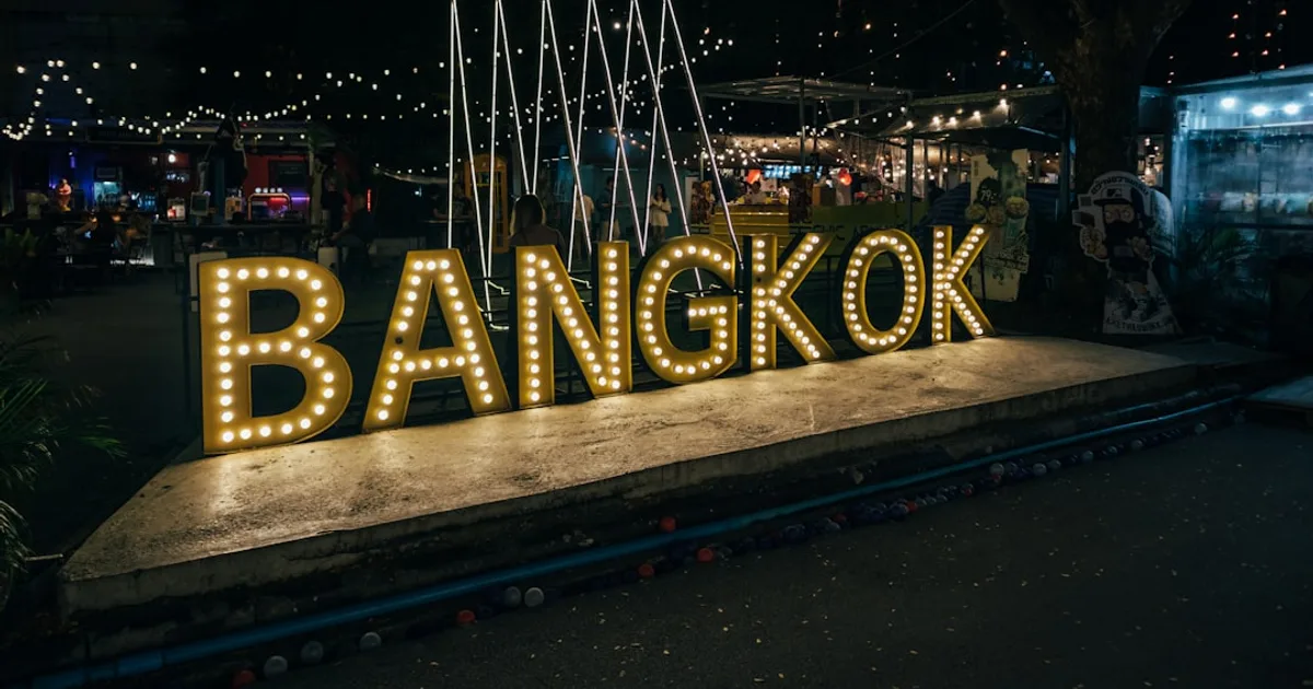 a sign that says bangkok lit up at night
